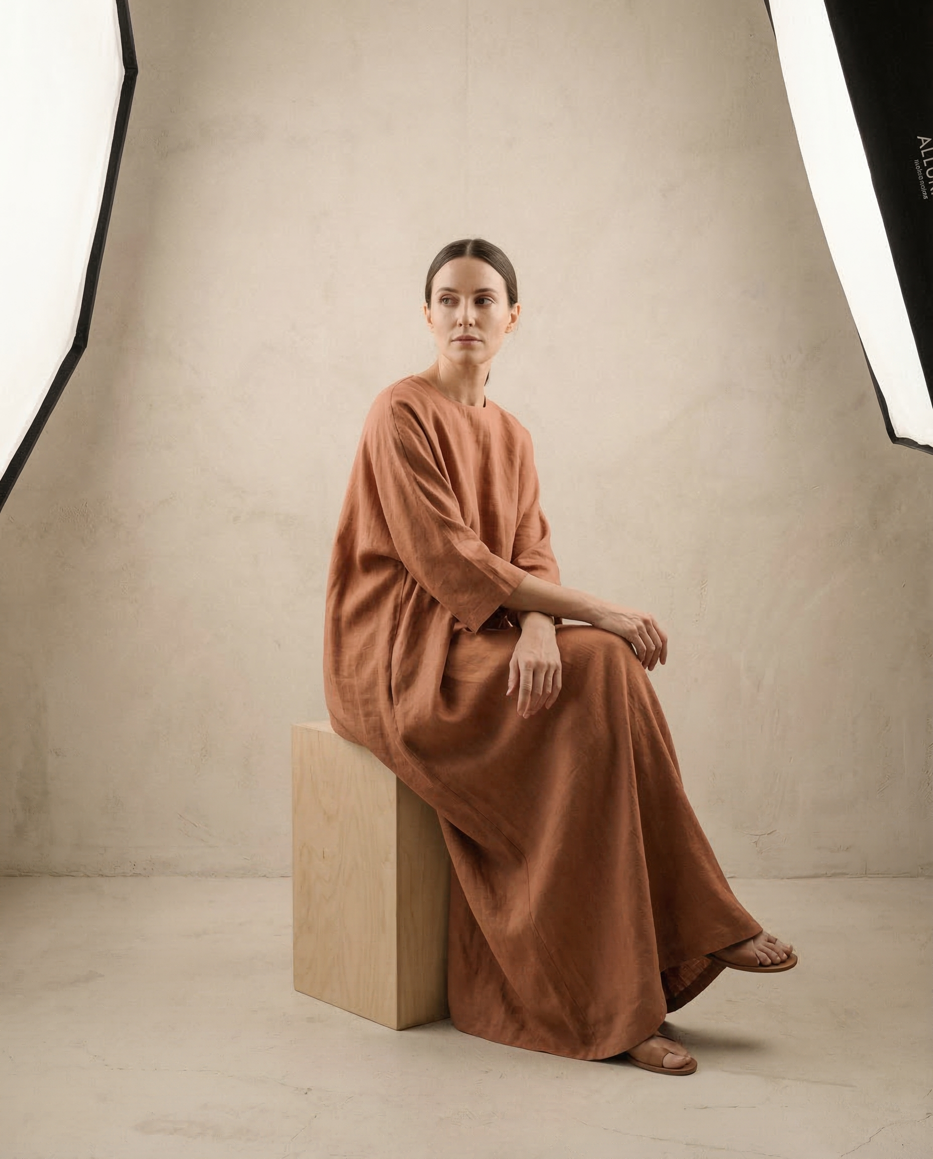 ALLURAE Lookbook — Robe longue en lin terracotta, pose contemplative en studio sur fond neutre